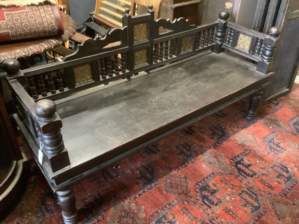 A Victorian Aesthetic period ebonised hall seat, the raised back with embossed glass inset panels, width 182cm depth 61cm height 96cm